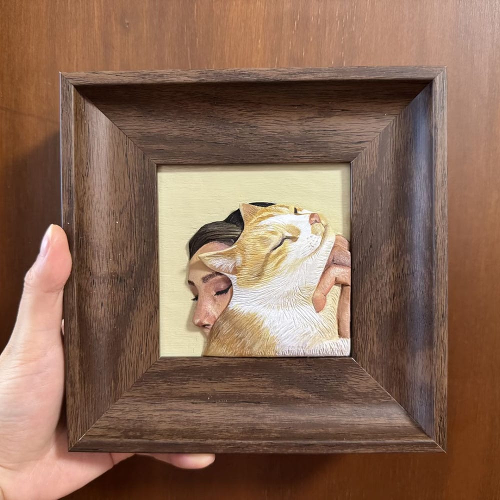 custom-pet-portrait-wood-carving-cat-owner-hug Custom pet portrait wood carving of an owner hugging a ginger cat, 3D hand-painted wooden relief art.