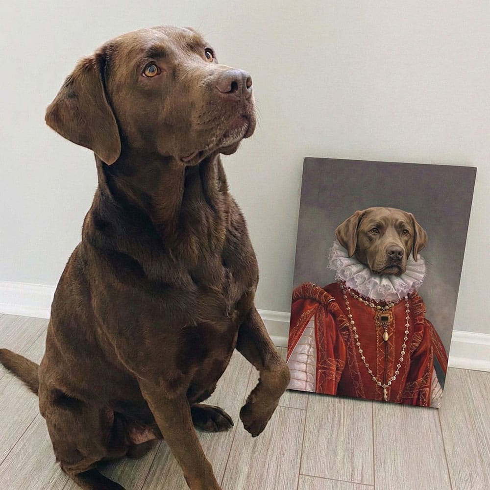 Real-life brown dog sitting next to a portrait of itself in regal attire on a white wall.