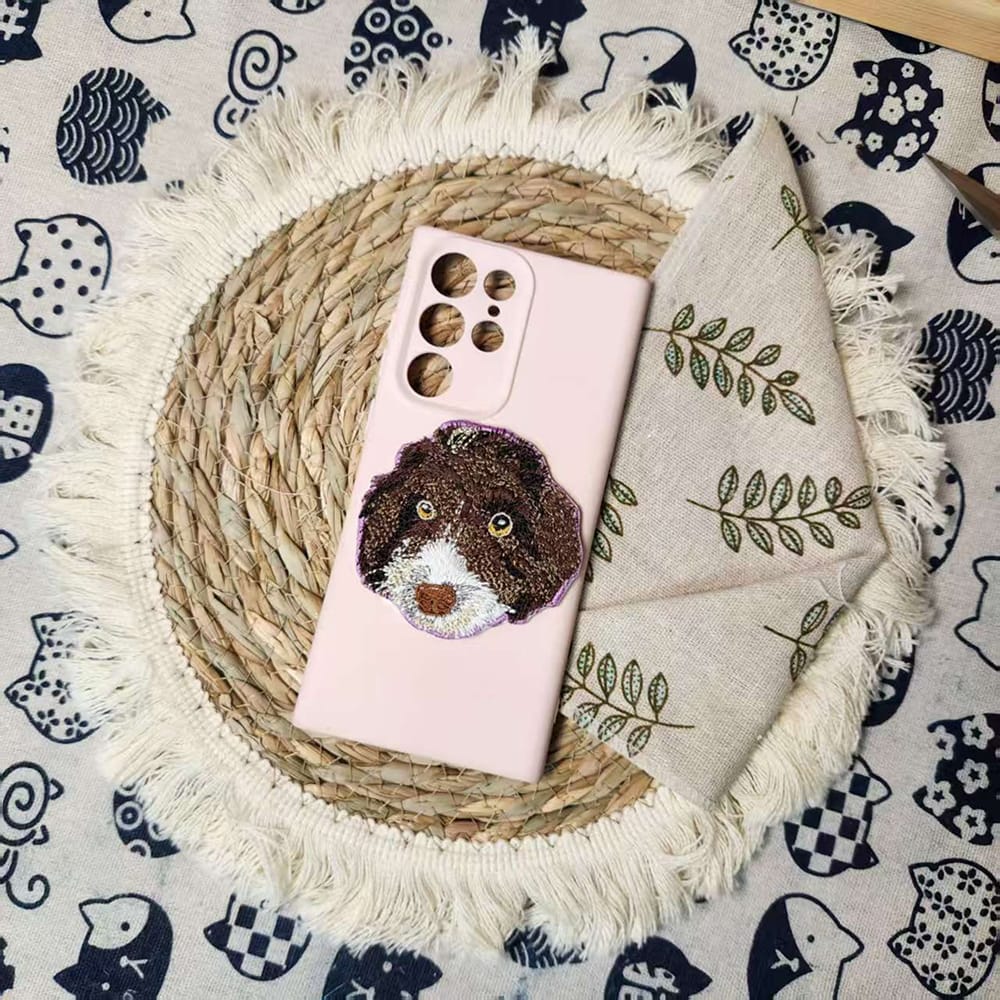 Close-up of a custom pet embroidery keychain showing a detailed portrait of a dog.