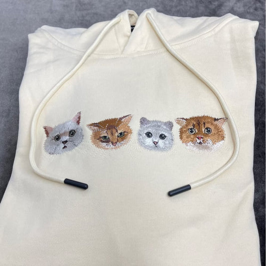 A custom embroidered hoodie featuring portraits of four different pets.