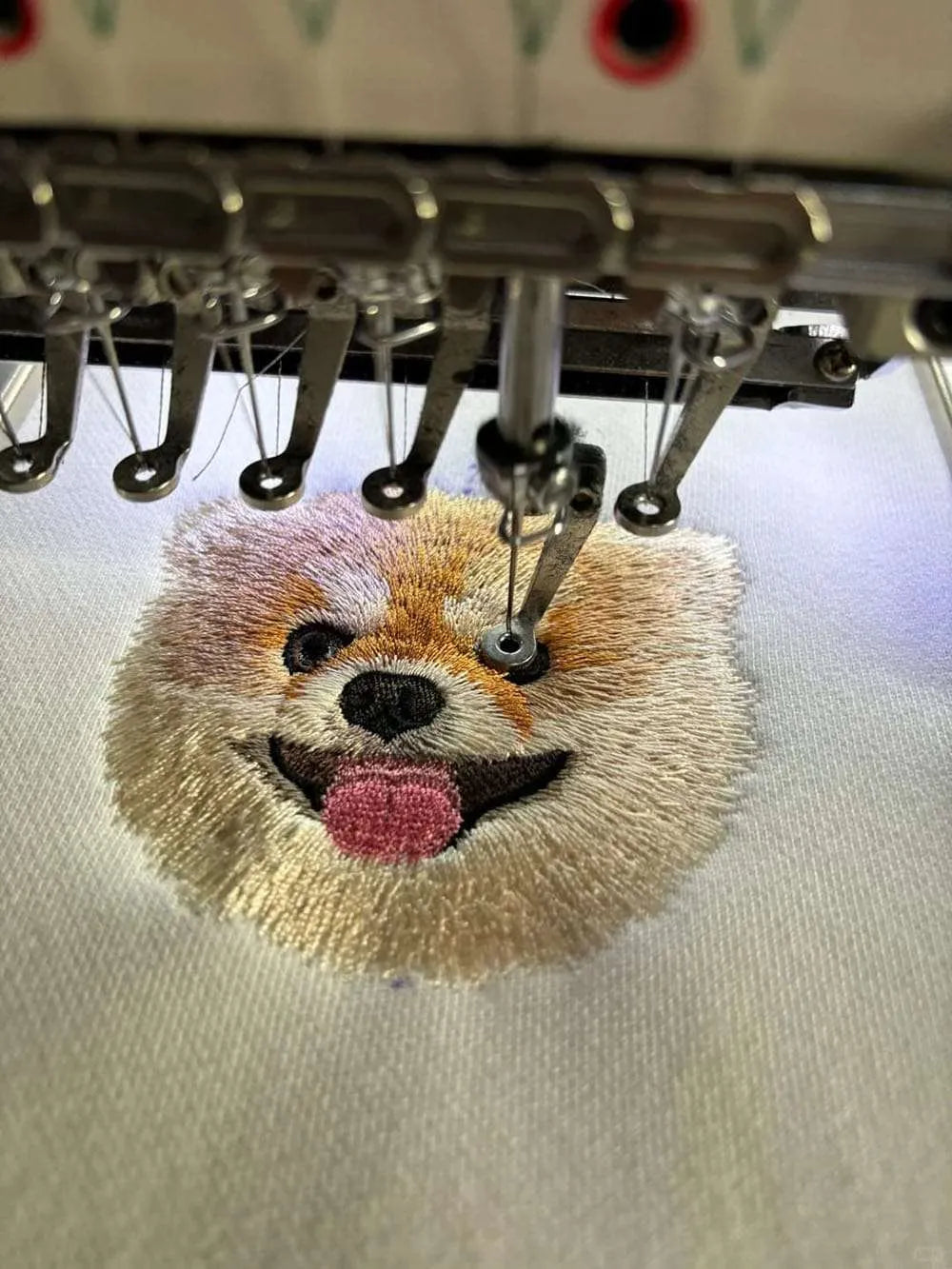 Making process of a custom embroidered pet portrait sweater.