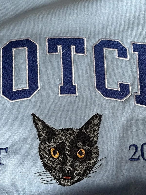 A custom sweatshirt featuring a detailed embroidered pet portrait.