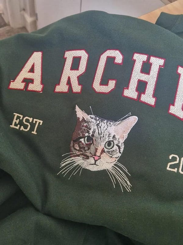 A custom sweatshirt featuring a detailed embroidered pet portrait.