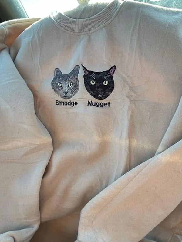 Beige sweatshirt with embroidered cats.