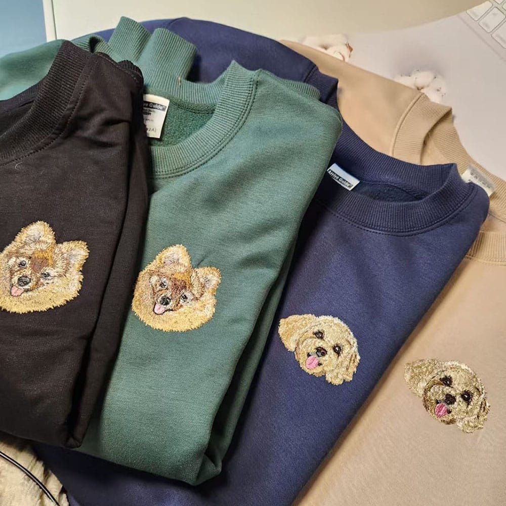 A collection of custom embroidered pet portrait sweatshirts in various colors.