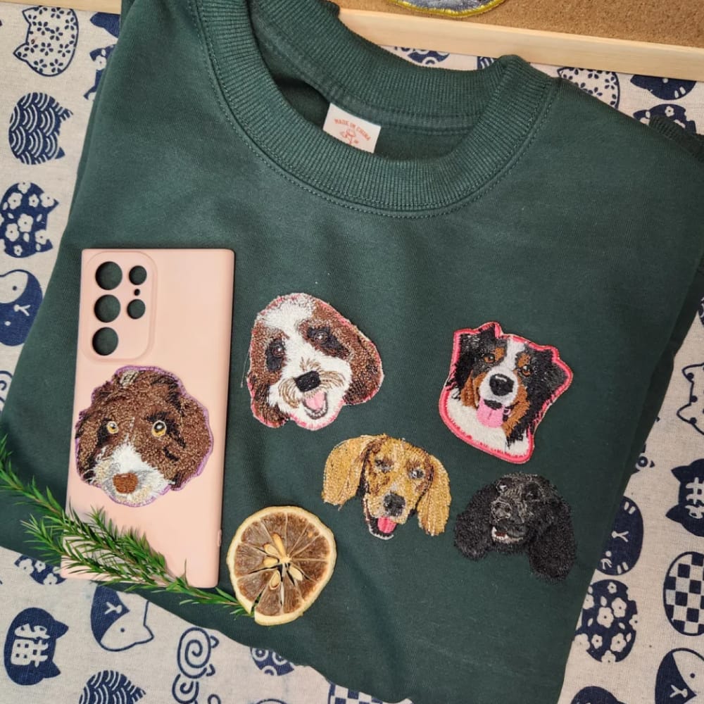 A green custom sweatshirt featuring a detailed embroidered pet portrait.
