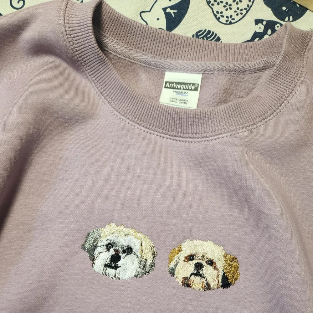 A purple custom sweatshirt featuring a detailed embroidered pet portrait.