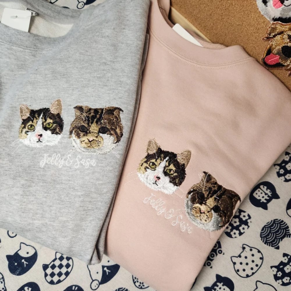 A custom sweatshirt featuring two detailed embroidered pet portrait.