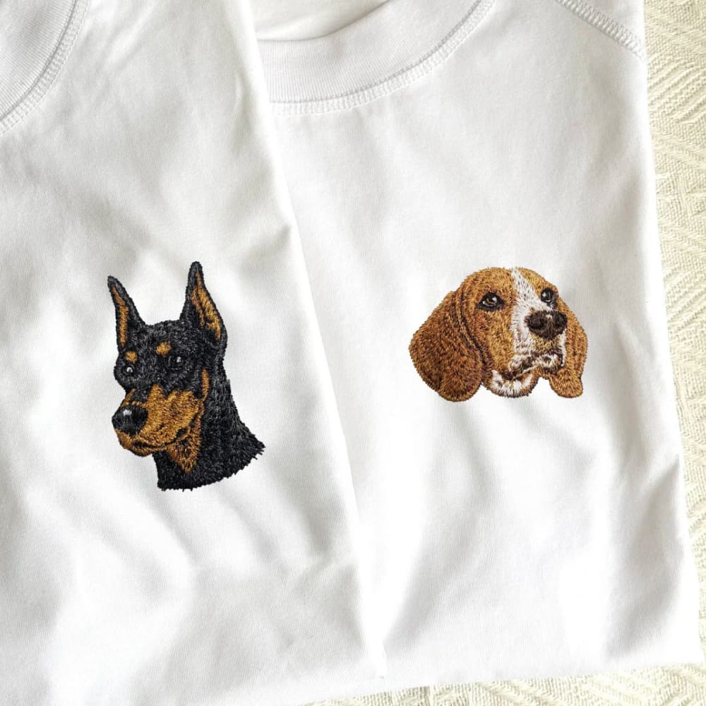 A white t-shirt featuring a custom embroidered pet portrait.