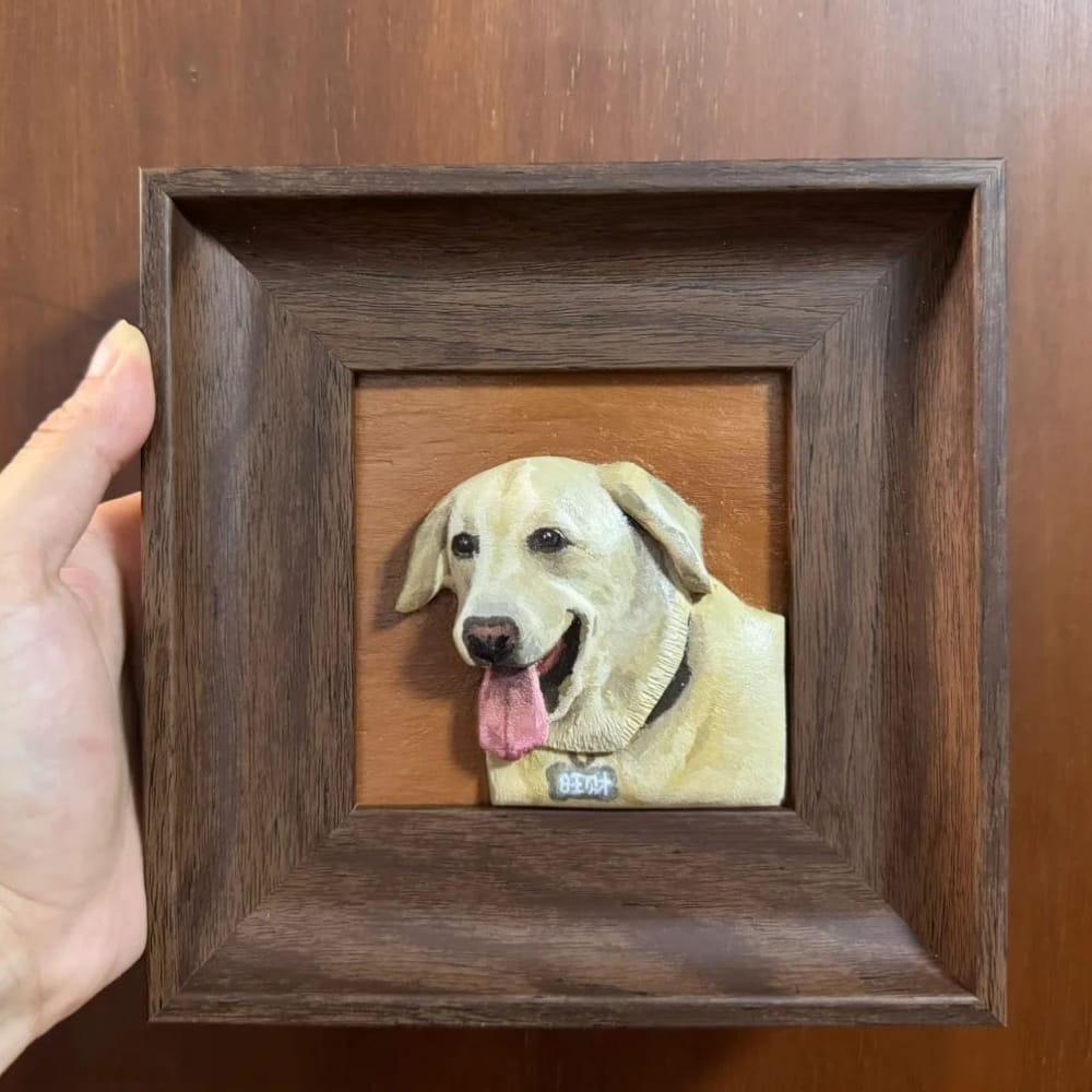 A custom pet portrait wood carving of a smiling yellow Labrador, displayed in a dark wood frame.