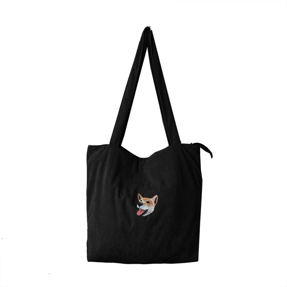 A black corduroy bag featuring a custom embroidered pet portrait.