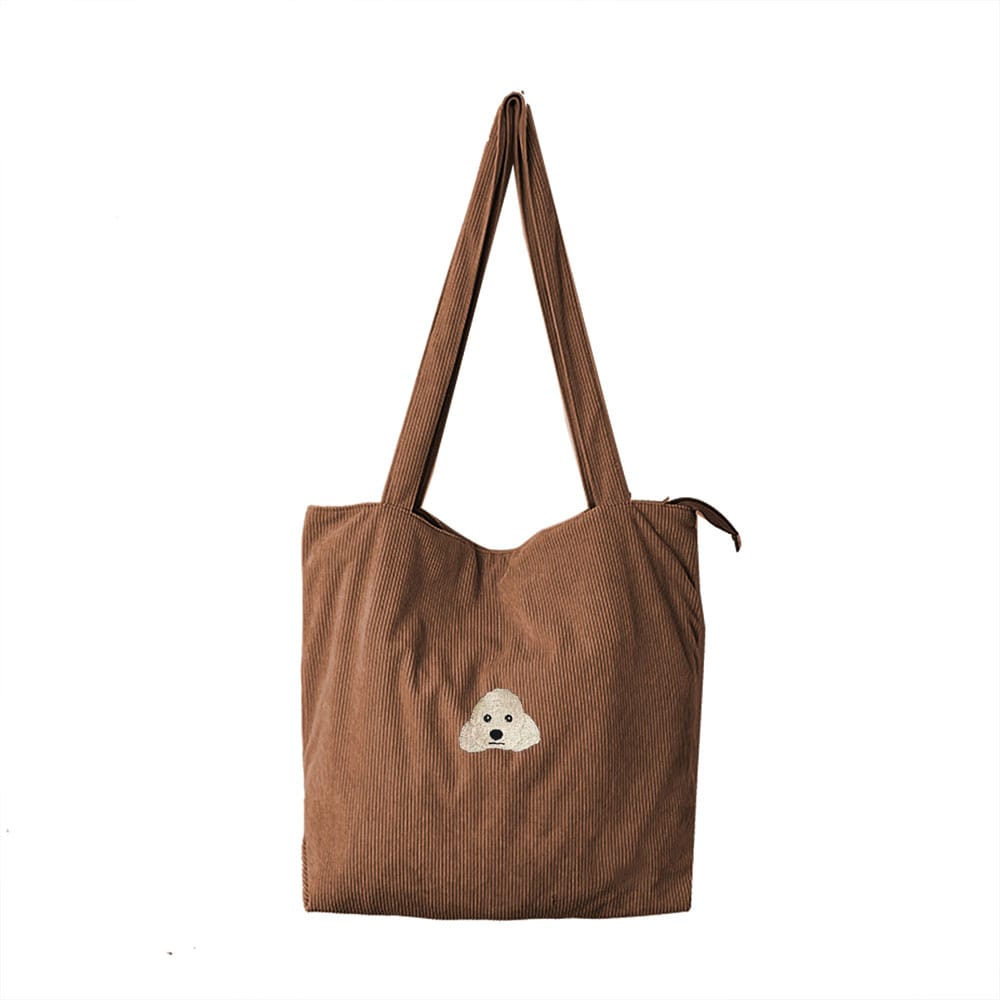 A brown corduroy bag featuring a custom embroidered pet portrait.