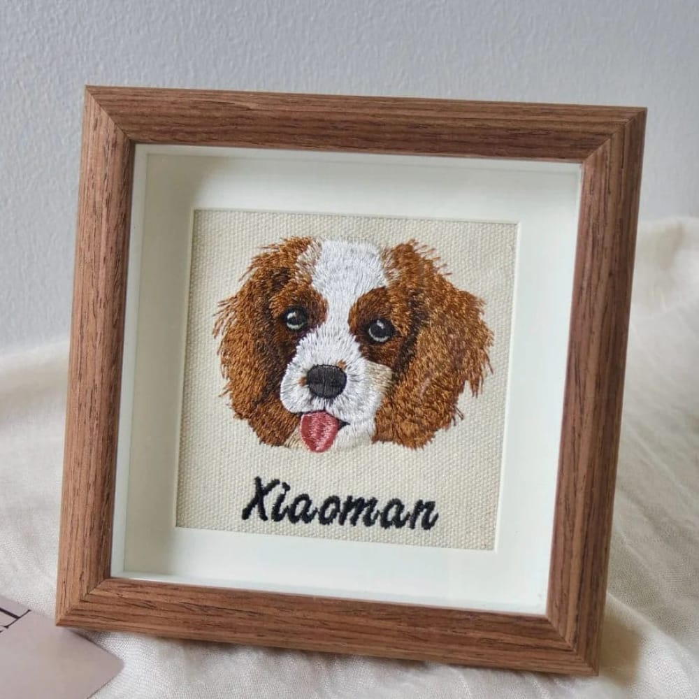 Framed custom embroidered dog portrait of a brown and white dog, personalized with the name.