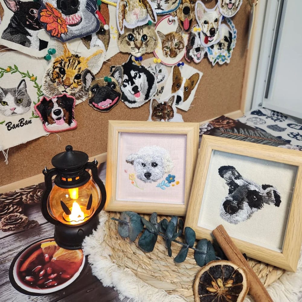 Collection of framed pet portraits and decorative items on a table with a lantern and dried fruits.