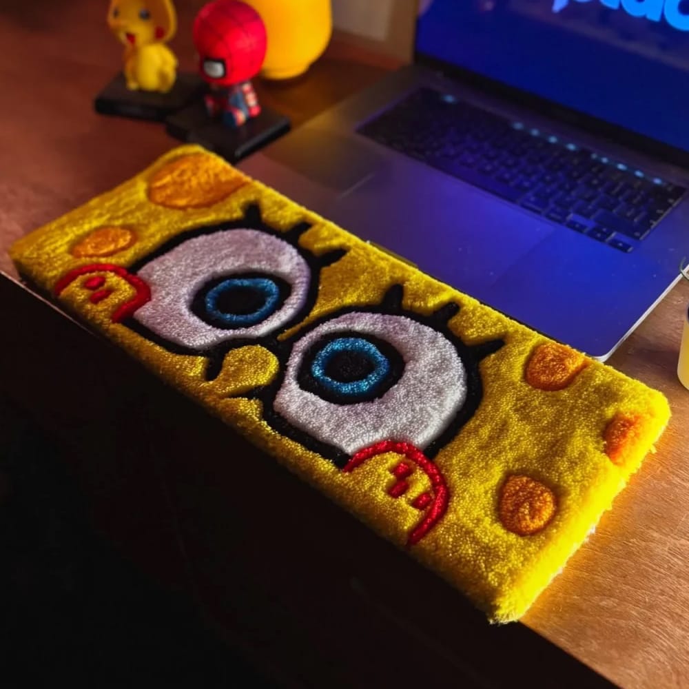 Collection of handmade keyboard desk mats, custom tufted in the shape of cartoon figures.