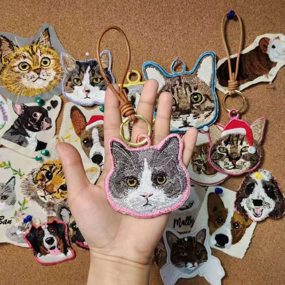 A personalized pet embroidery keychain hanging from a set of keys.
