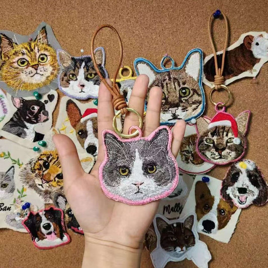 A personalized pet embroidery keychain hanging from a set of keys.