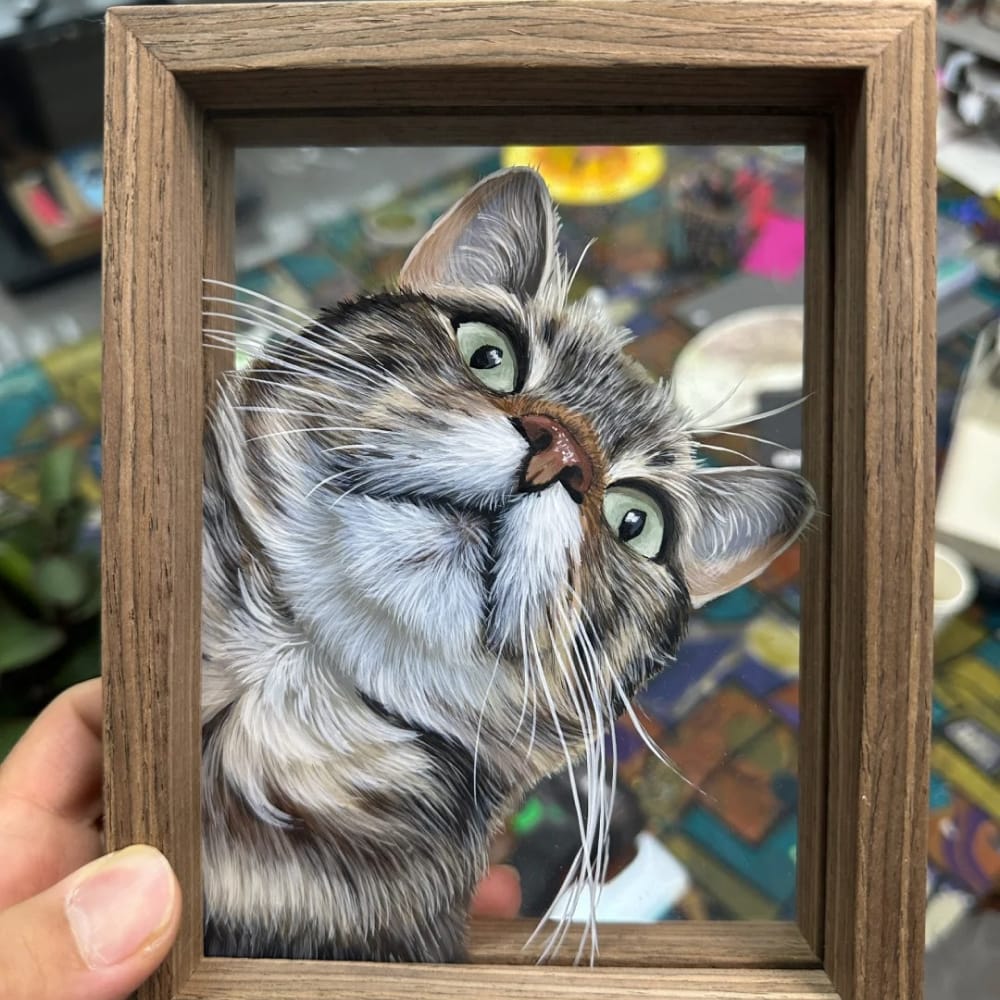 Personalized pet portrait on single-layer glass featuring a hand-painting of a tabby cat looking up.