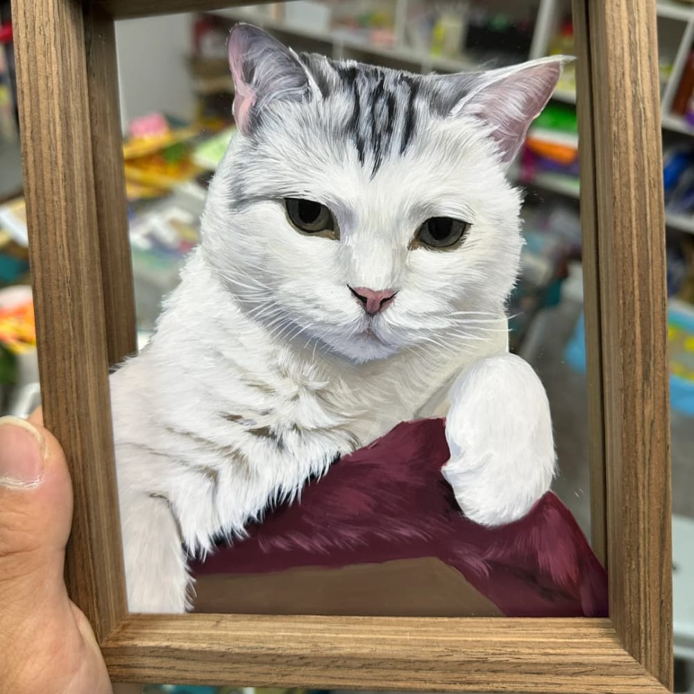 A personalized pet portrait on single-layer glass, hand-painted with a realistic white tabby cat resting on a cushion.
